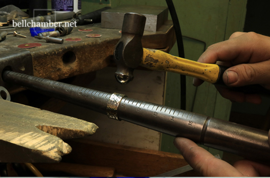 Hammering a ring to make it textured on a steel mandrel.